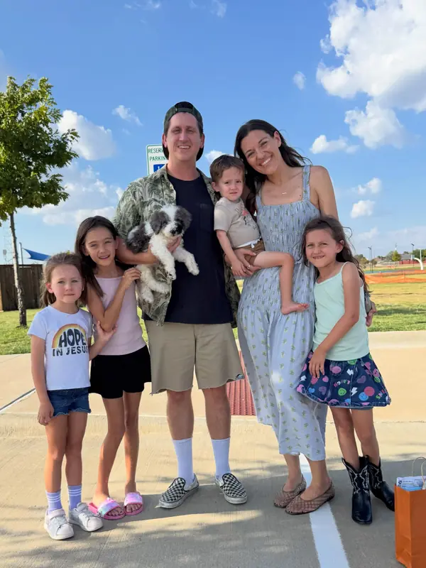 A family on gotcha day, taking home their Bernedoodle puppy from KK Doodles